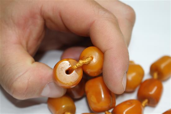 A single strand barrel shaped amber bead necklace, 86cm.